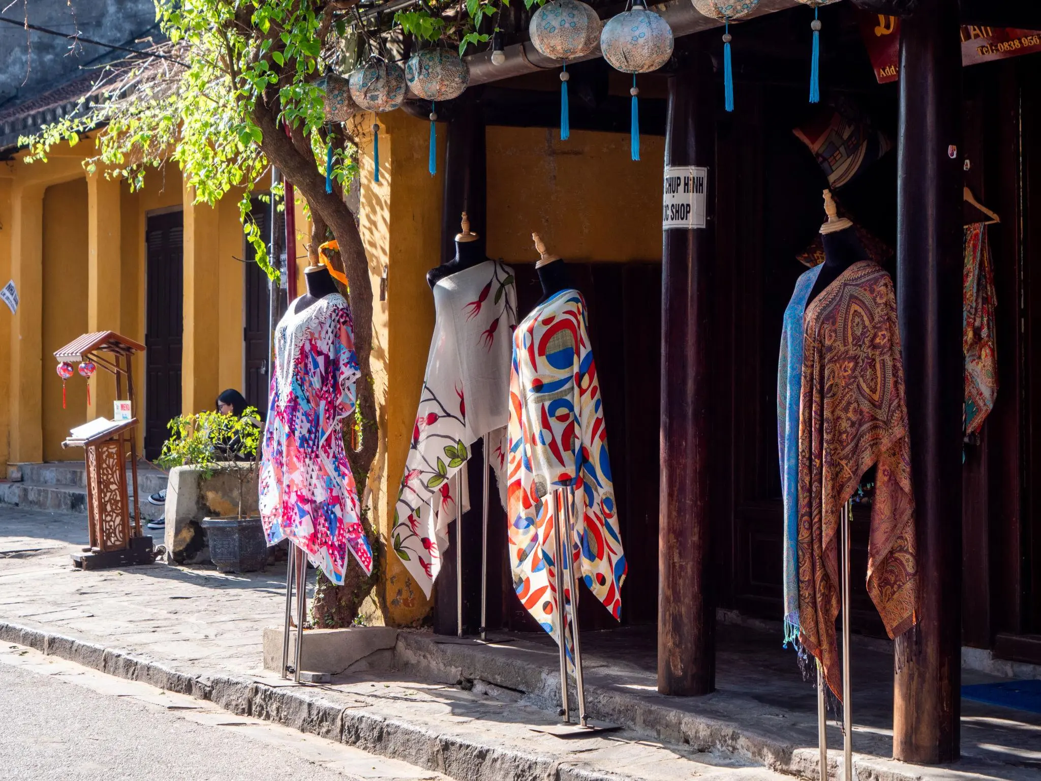 Hoi An tailor shop with colorful fabrics and clothing displays in Old Town