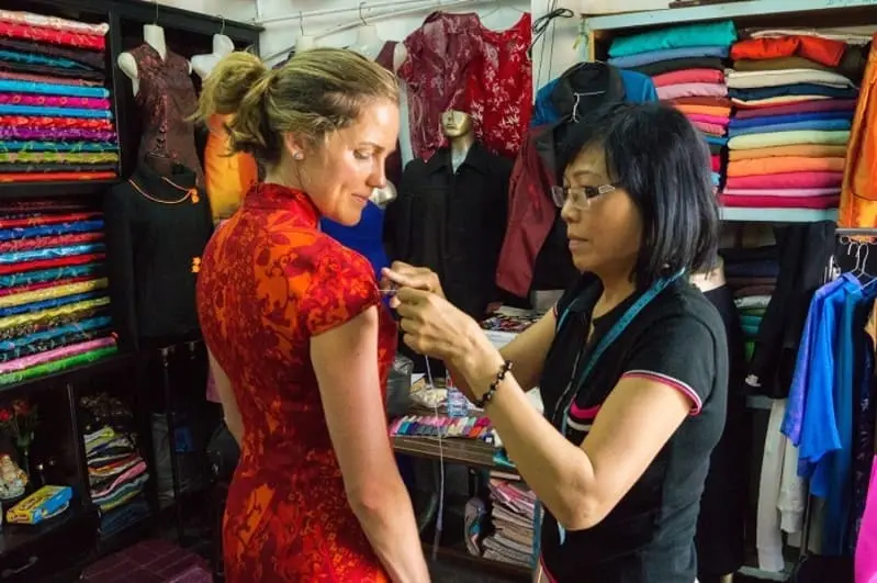 Hoi An tailor taking measurements for custom clothing