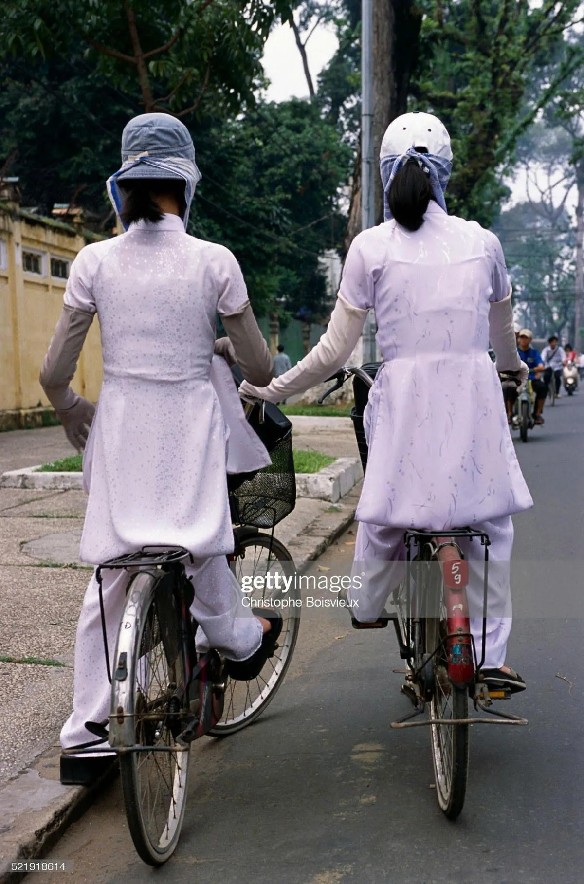 Two pretty girls ride bikes to school.