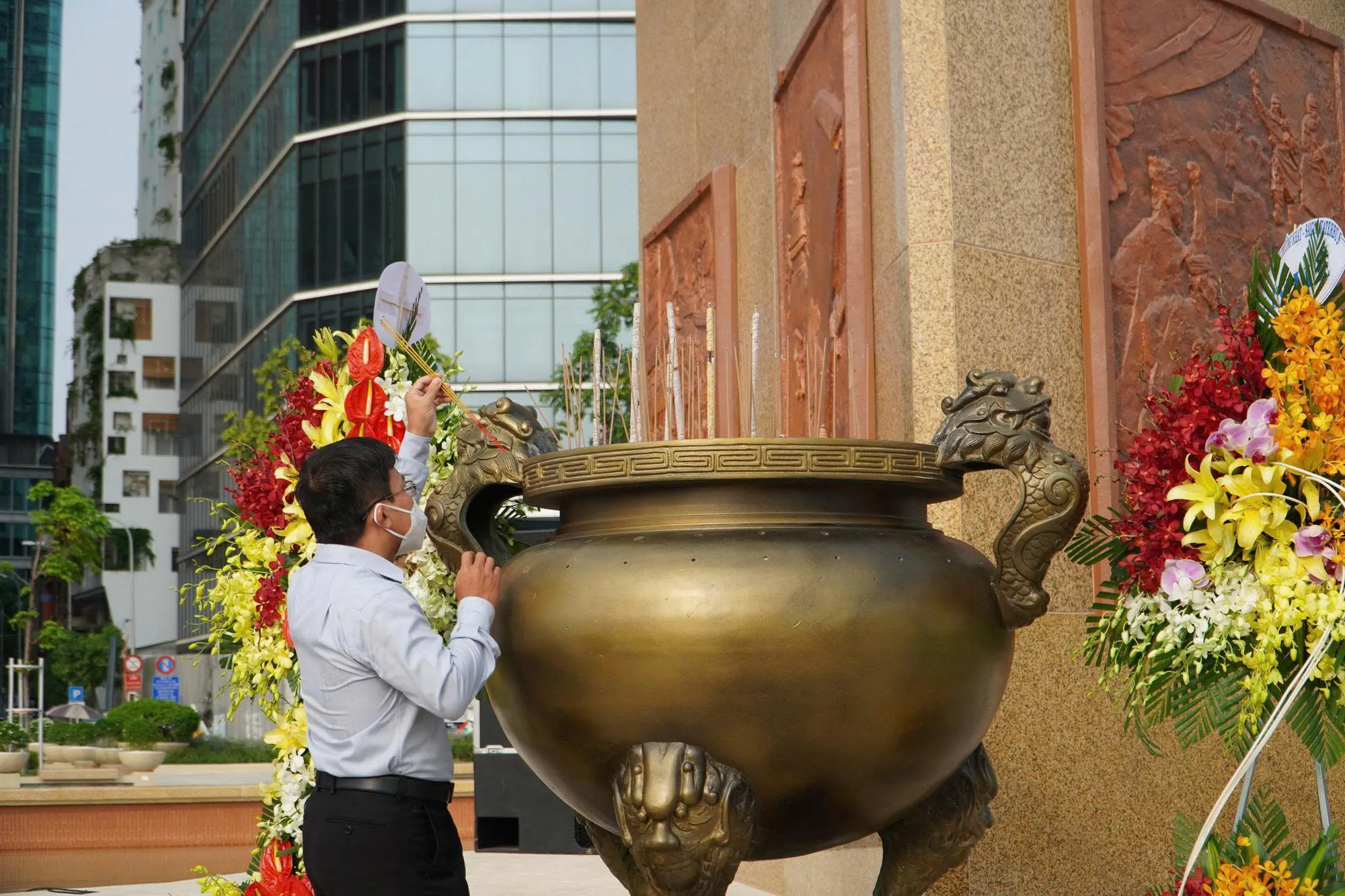 Vietnamese people offering incense at a war memorial