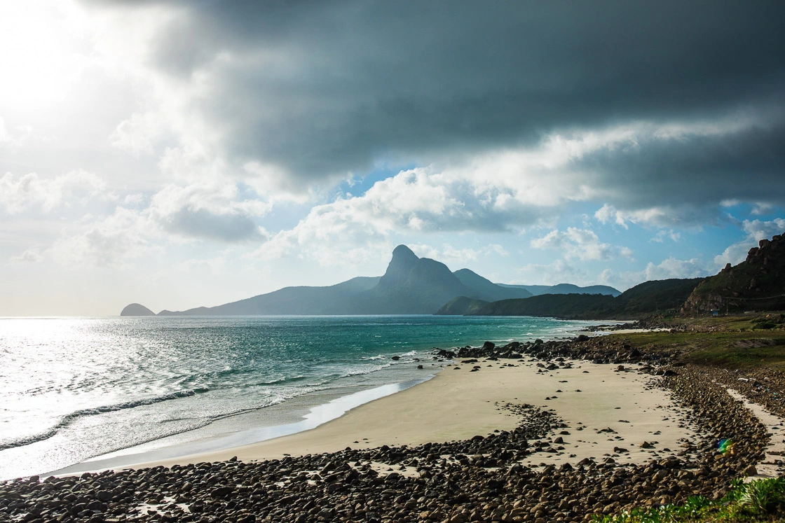 Con Dao beach with mountainous backdrop and clear water